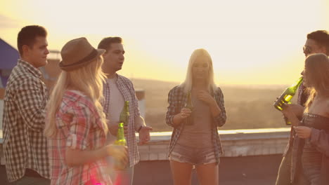 A-company-of-young-people-communicates-on-the-roof-and-drink-beer-on-a-summer-evening